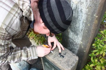<p>Signing the logbook of a micro cache. This cache is too small to hold anything but a strip of paper!</p>