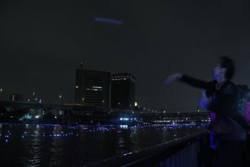 A group of ladies tossing (more like throwing baseball-style) their inori boshi into the river before they leave. The aim seems to be getting it as far as possible – which would explain the baseball-style throwing.