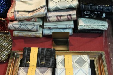 The owner, Seiko Yamazaki, designs the obi patterns. Surprisingly popular is her spectacles-patterned men's obi. Displayed below are name card holders made from obi fabric.