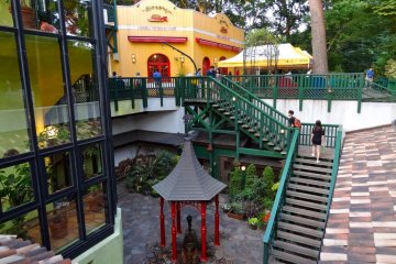 <p>A view of the Ghibli Museum Caf&eacute; and the central gazebo with the hand pump water well</p>