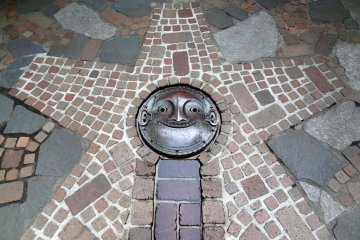 <p>Don't forget to look down when walking throughout the museum grounds. Here's a smiling face strategically placed at the end of the tiled stream of fresh water from the hand pump well</p>