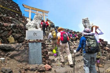 <p>Almost there! With the shisa lions flanked on each side, climb through the torii gate and you've finally reached the summit. Hooray!</p>