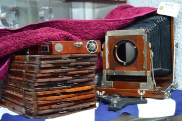 Old camera which still has a long accordion-like lens.