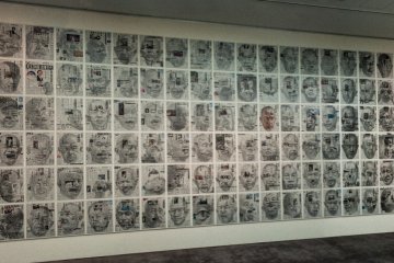 <p>The room is filled with drawings of Yoshimura's face on newspapers.</p>