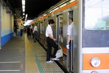 Garis dan/atau lantai keramik yang menunjukkan di mana letak pintu gerbong saat kereta tiba