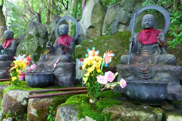 Colorful offerings of flowers rest in front of these statues