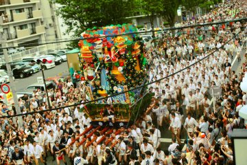 A spectacular float surges down the street, carried by 30 men at a time