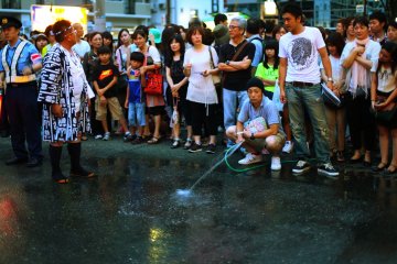 The crowds help to wet the street in preparation for the race