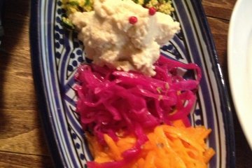 Appetizer plate with hummus, couscous, and pickled vegetables