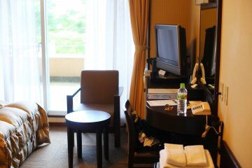 Room interior: wide screen TV, LAN cable, desk and two chairs.