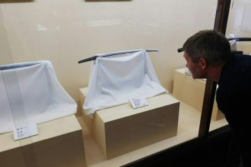 Admiring the swords at the Nomura clan samurai residence.