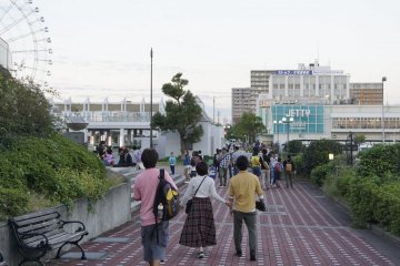 People moving to and fro, sitting by the benches, or entering the shopping areas