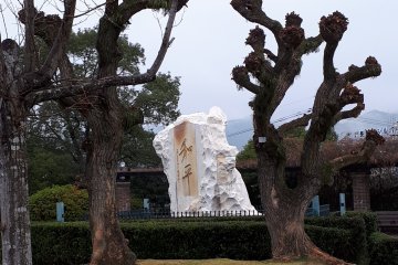 The stone's calligraphy says 'wahei' or peace, the characters reversed from the usual reading of 'heiwa'
