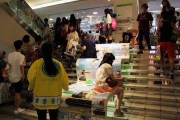 Shoppers get tired out from all the spending and rest in the stairwell.