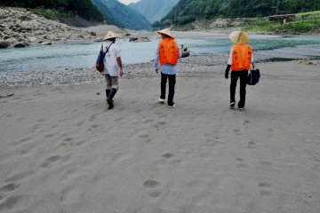 Visitors are provided with life vests and conical Asian hats during the tour