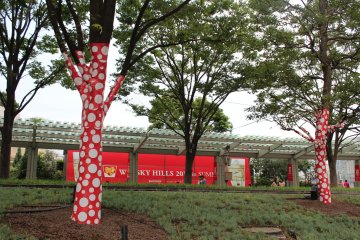 Nearby trees are wrapped in matching red polka dot casing to celebrate the Kusama collaboration.