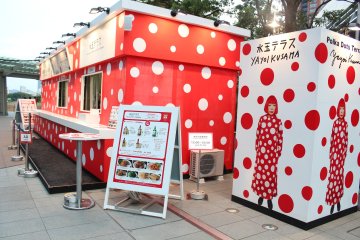 Take a photograph next to Yayoi Kusama's lifesize image.