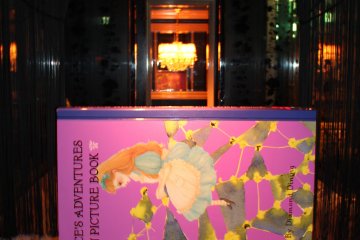 Certaines tables sont séparées par d'imposants "livres" d'Alice au Pays des Merveilles
