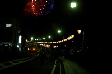 lanterns on the road & fireworks overhead