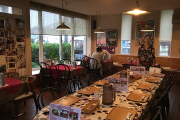Restaurant interior and owner Akie Konishi at the head of the table.