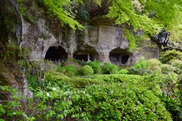 Shrines built into the rocks in a garden at Houkoku-ji temple