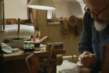 Artisan painting a kokeshi doll