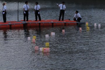 Lanterns are passed hand over hand to be put into the river