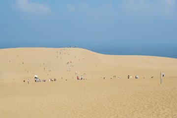 <p>Cette photo a &eacute;t&eacute; prise depuis la zone de randonn&eacute;e &agrave; dos de chameau, et montre des touristes effectuant un p&egrave;lerinage jusqu&rsquo;au sommet de la dune de sable. Comme vous pouvez le voir, cela constitue une courte promenade</p>