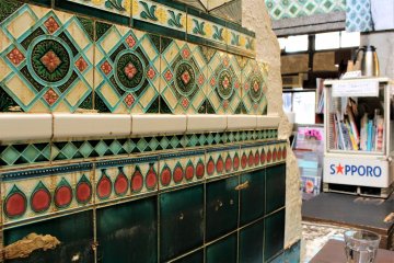 The wall is covered with colourful Majolica tiling