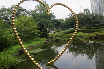 Kin no Kokoro, a sculpture by Jean-Michel Othoniel, reflects in the pond