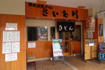 The entrance with many colorful advertisements and promotions offsetting the traditional wooden look
