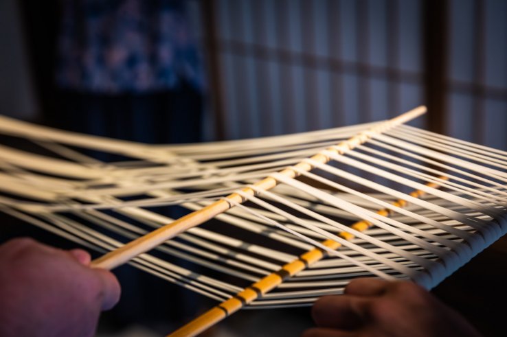 The traditional way: udon noodles are separated with wooden sticks before hanging to dry
