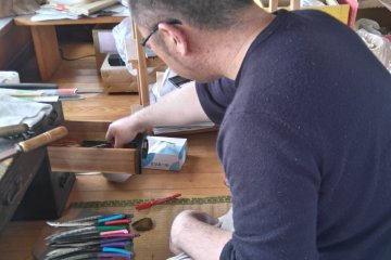 A grumpy craftsman polishing his blades
