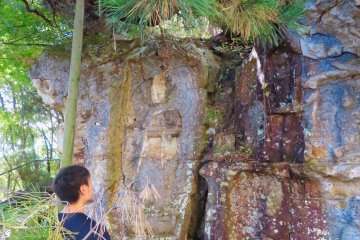 Studying the carvings at Iwaya Kannon
