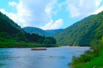 A solitary boat glides between the hills.