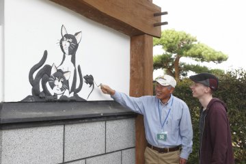 Local guide showing a traditional kote-e relief painting