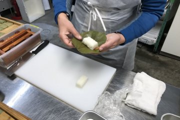 Put the topping on a persimmon leave, then add the rice and wrap all up. 