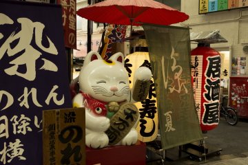 A Maneki Neko beckoning cat of such a size can only bring good fortune at Sennichimae arcade