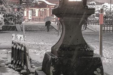 Stone lantern flickering in the early evening.