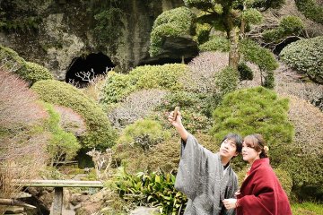 A couple in traditional costume points to the bamboo grove