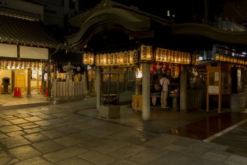 The lanterns of the shrine illuminate the cobblestones at night at Hozenji Yokocho between Nanba and Dotonbori