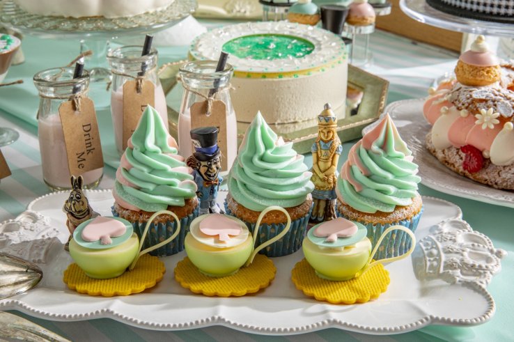 The Alice's Mirror cake can be seen in the background