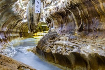 Spelunking in Senbutsu Cave requires a walk through chilly waters