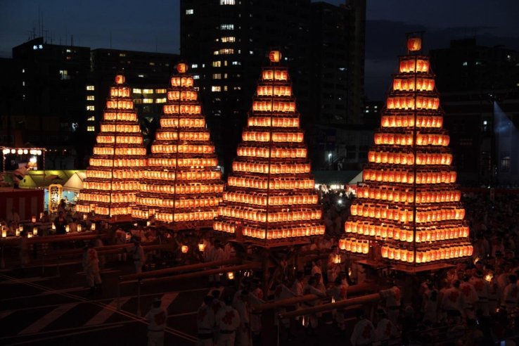 Towers of lanterns are carried during the Tobata Gion Festival