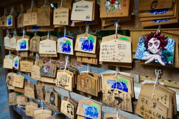 Patrons show off their art skills and love for the series by doodling on enma tablets used for making wishes