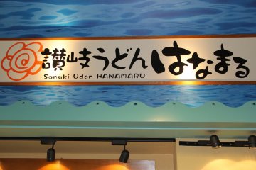 Papan Hanamaru dalam Bahasa Inggris dan Jepang, carilah papan nama ini di Pusat Perbelanjaan Ryuku Aeon Gushikawa