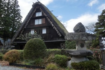 Straw-thatched Gassho-zukuri houses exhibit old-styled farming implements