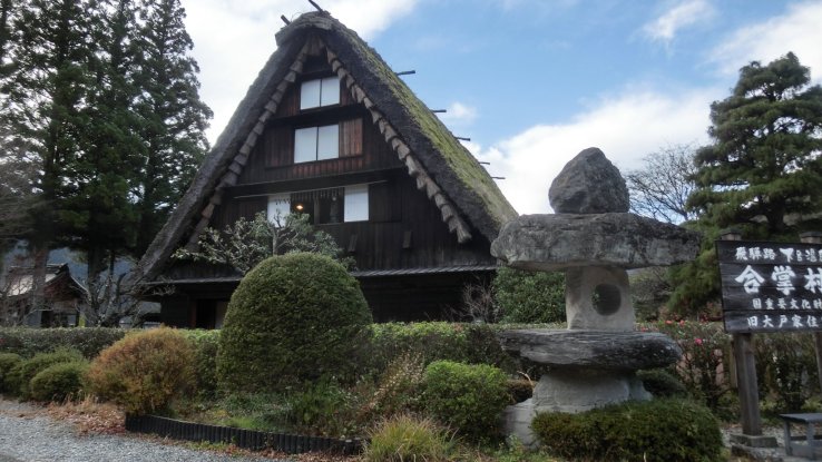 Straw-thatched Gassho-zukuri houses exhibit old-styled farming implements