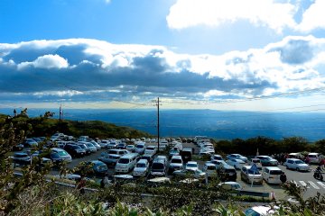 The packed parking lot near the ropeway, with the Kanto Plain in the background