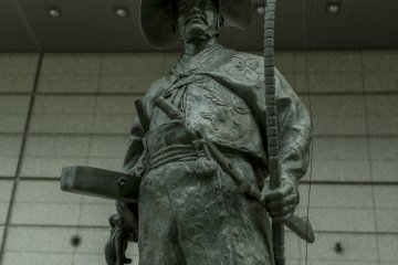 A large statue of a Samurai lending a regal prescence to a modern cathedral of minds
